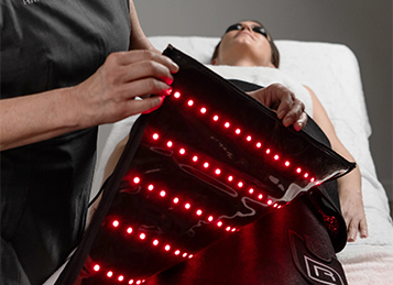 Sesión de rejuvenecimiento corporal aplicando bandas de LED rojo para estimular colágeno y reafirmar la piel en Flash Belleza Valencia.